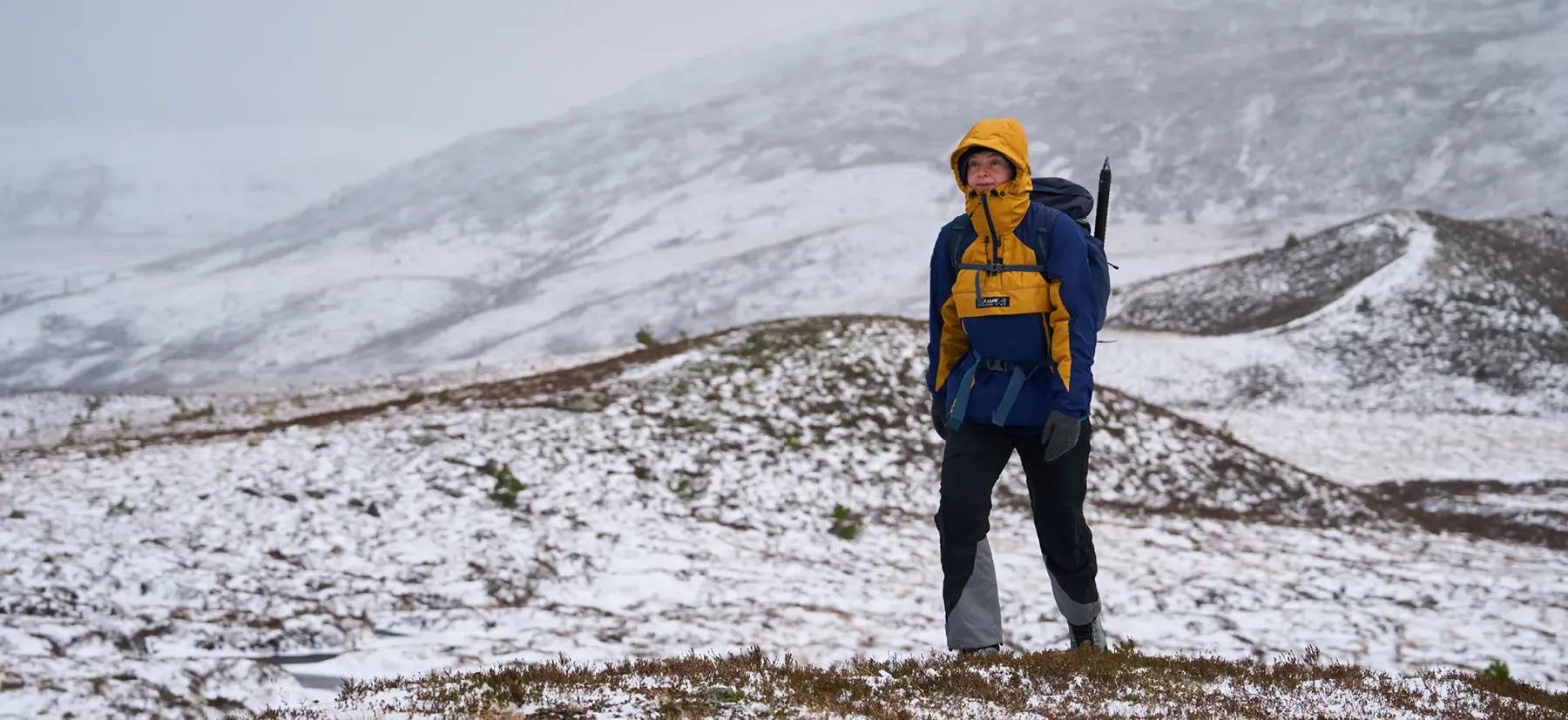 Hiking Woman on Snowy Mountain in warm waterproof paramo Recycled Polyester Technical Outdoor Smock - Higher Resolution